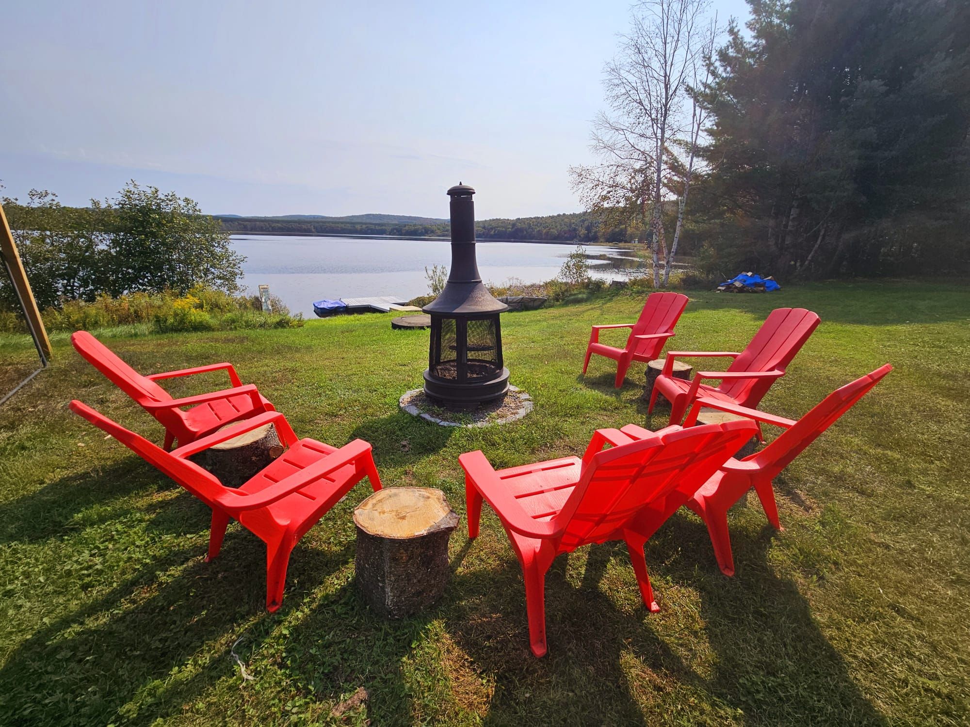 Cozy chairs around the firepit with a lake view at Chalet Nantel